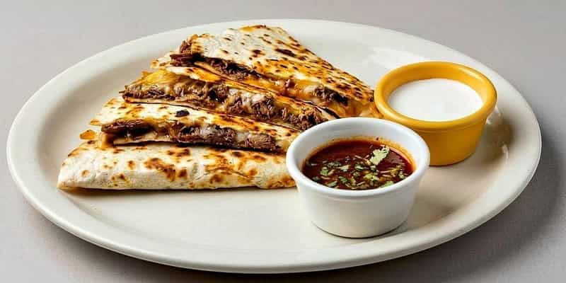 Shredded beef quesadilla with salsa roja and crema