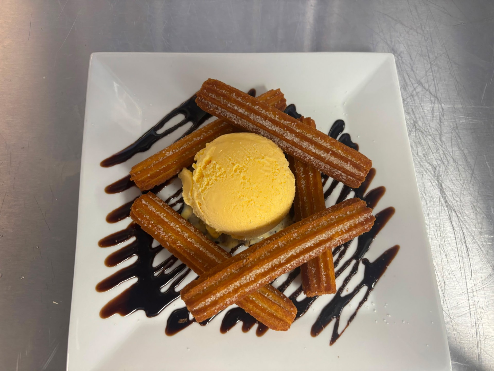 Churros with vanilla ice cream and chocolate drizzle