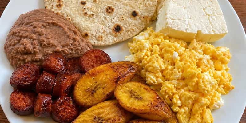 Latin breakfast plate with eggs, plantains, chorizo, beans and tortillas
