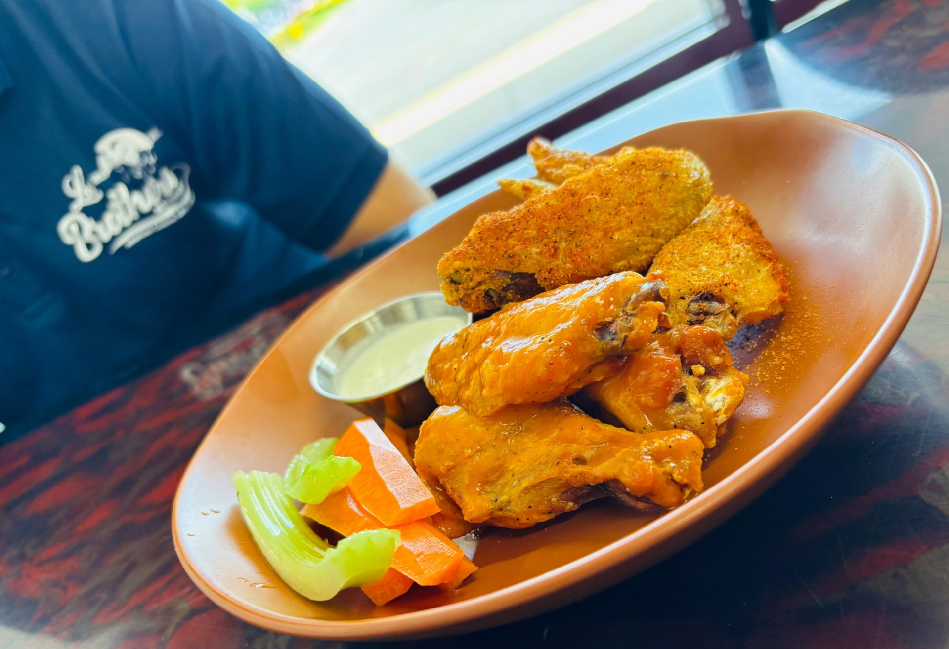 Buffalo and dry-rub chicken wings with celery and carrots